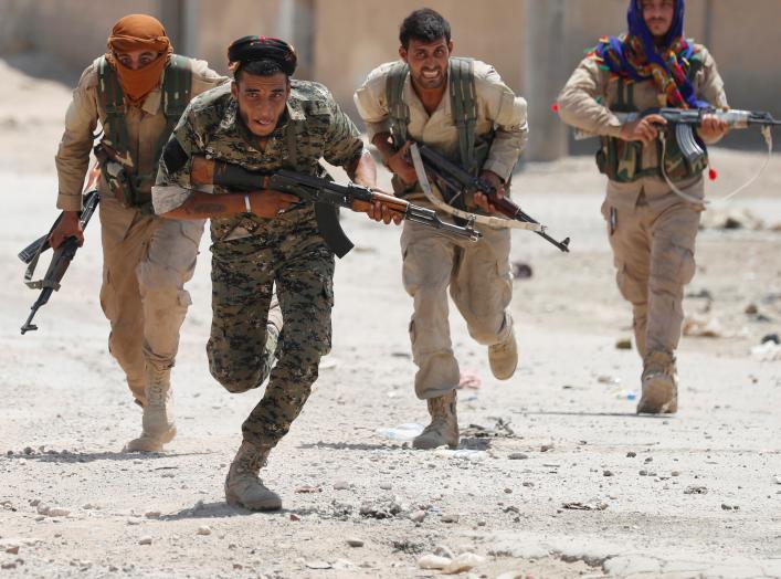 Kurdish fighters from the People's Protection Units (YPG) run across a street in Raqqa, Syria July 3, 2017. REUTERS/Goran Tomasevic